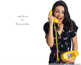 Картинка Мила Кунис звонит по желтому телефону